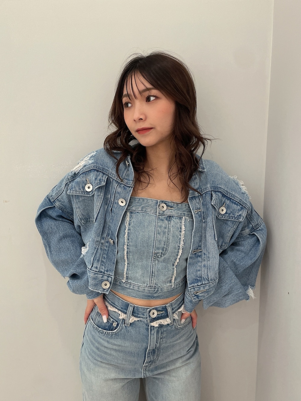 ホワイト系のサンダル、ブルー系のチューブトップ、ブルー系のデニムジャケットを着用したレディースの春コーディネートの4枚目の写真