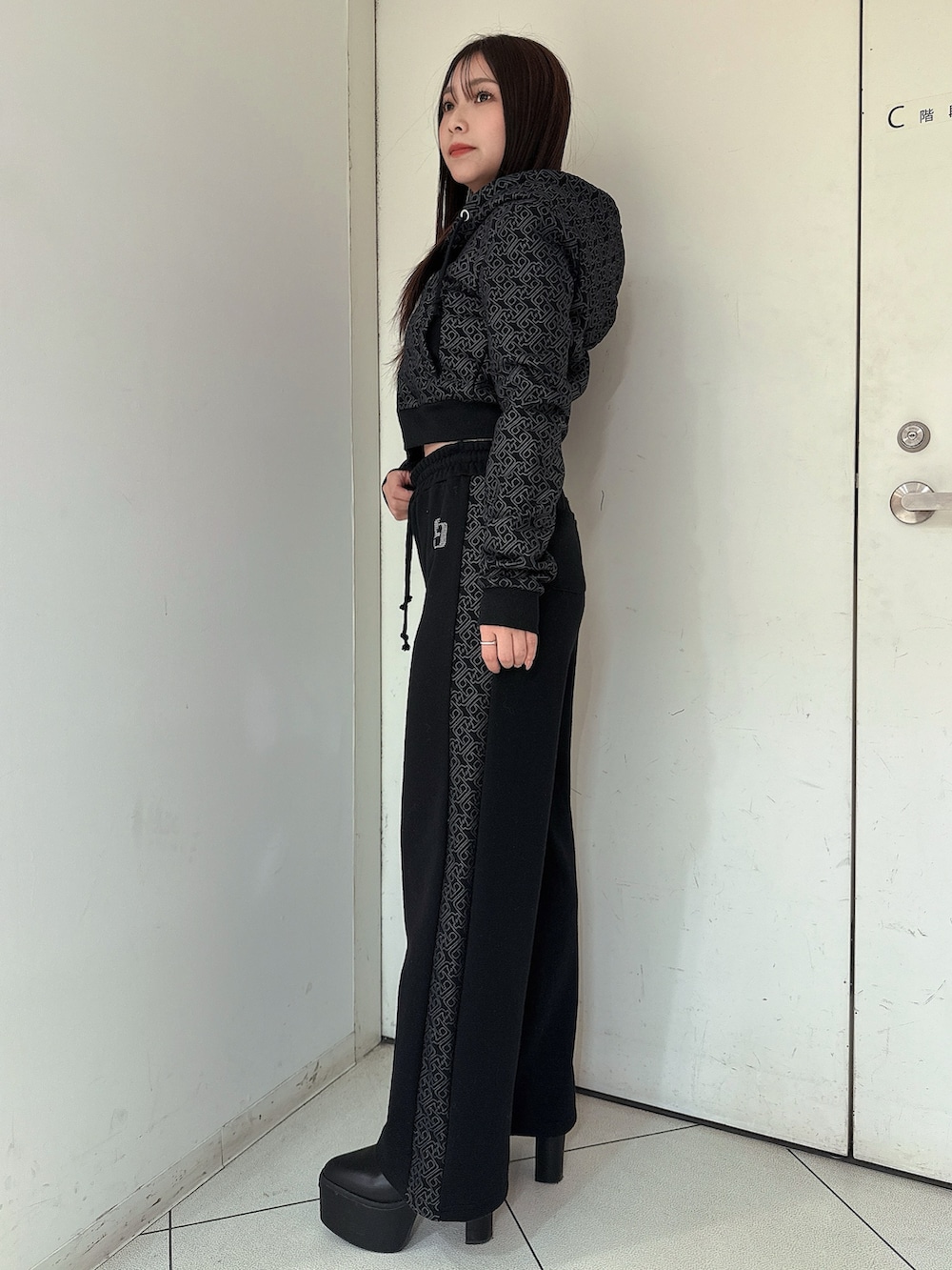 ブラック系のスウェットパンツ、ブラック系のパーカー、ブラック系のブーツを着用したレディースの冬コーディネートの2枚目の写真