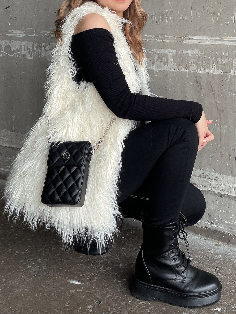 ブラック系のTシャツ/カットソー、ホワイト系のベスト、ブラック系のデニムパンツを着用したレディースの秋コーディネートの6枚目の写真