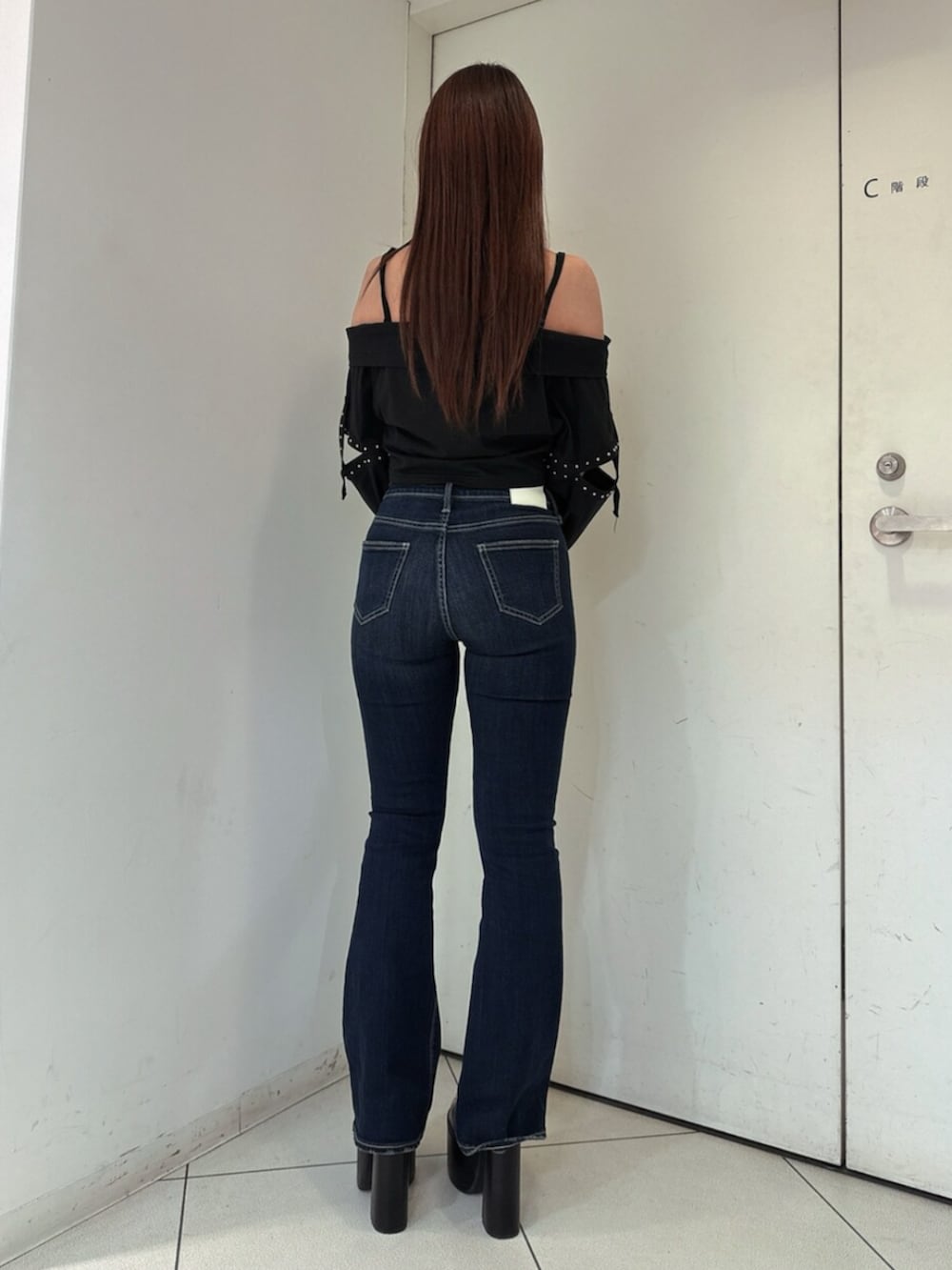 ブルー系のデニムパンツ、ブラック系のサンダル、ブラック系のTシャツ/カットソーを着用したレディースの春コーディネートの3枚目の写真