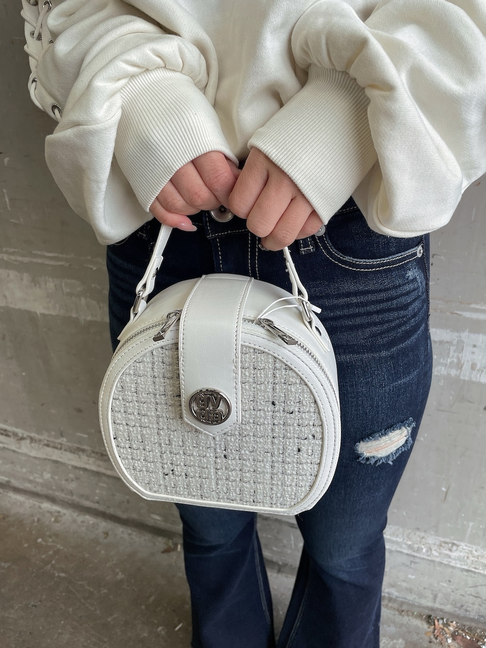 ホワイト系のスウェット、ホワイト系のハンドバッグ、ホワイト系のパンプスを着用したレディースの春コーディネートの9枚目の写真