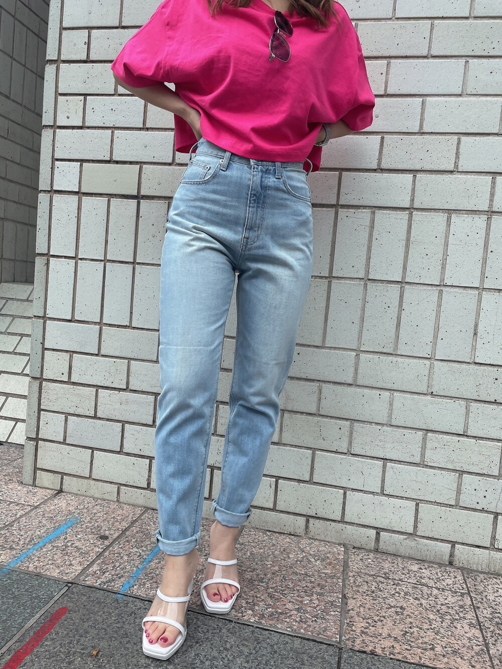 ブルー系のデニムパンツ、ホワイト系のサンダル、ピンク系のTシャツ/カットソーを着用したレディースの夏コーディネートの6枚目の写真