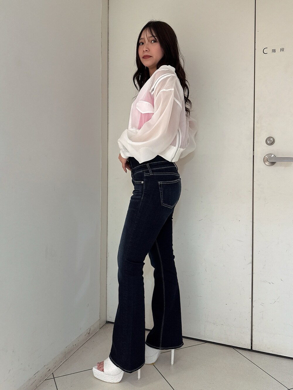 ブルー系のデニムパンツ、ホワイト系のブルゾン、ピンク系のキャミソールを着用したレディースの春コーディネートの2枚目の写真