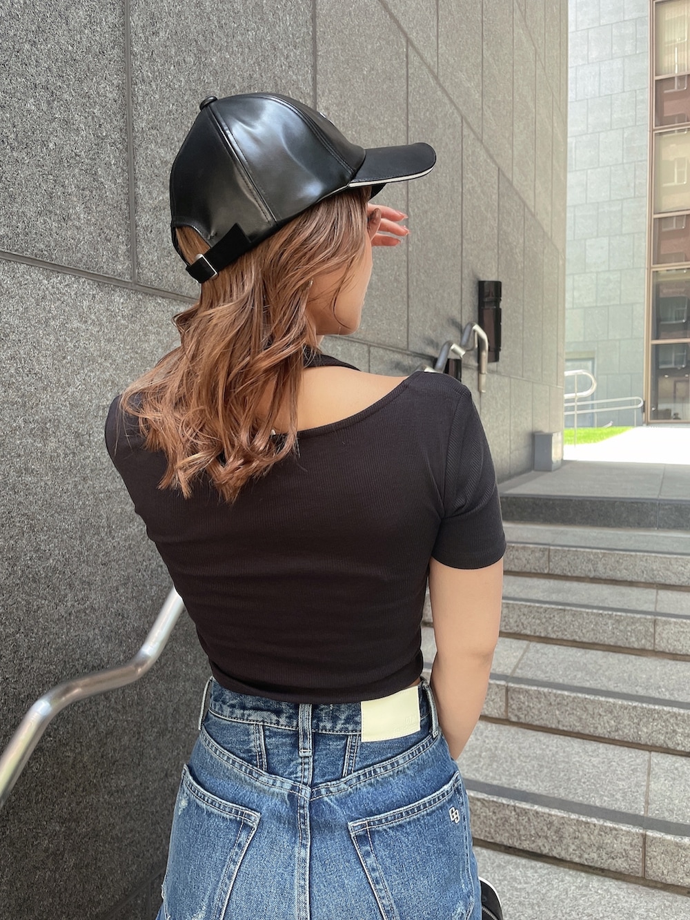 ブラック系のTシャツ/カットソー、ブルー系のデニムパンツ、ブラック系のサンダルを着用したレディースの春コーディネートの4枚目の写真
