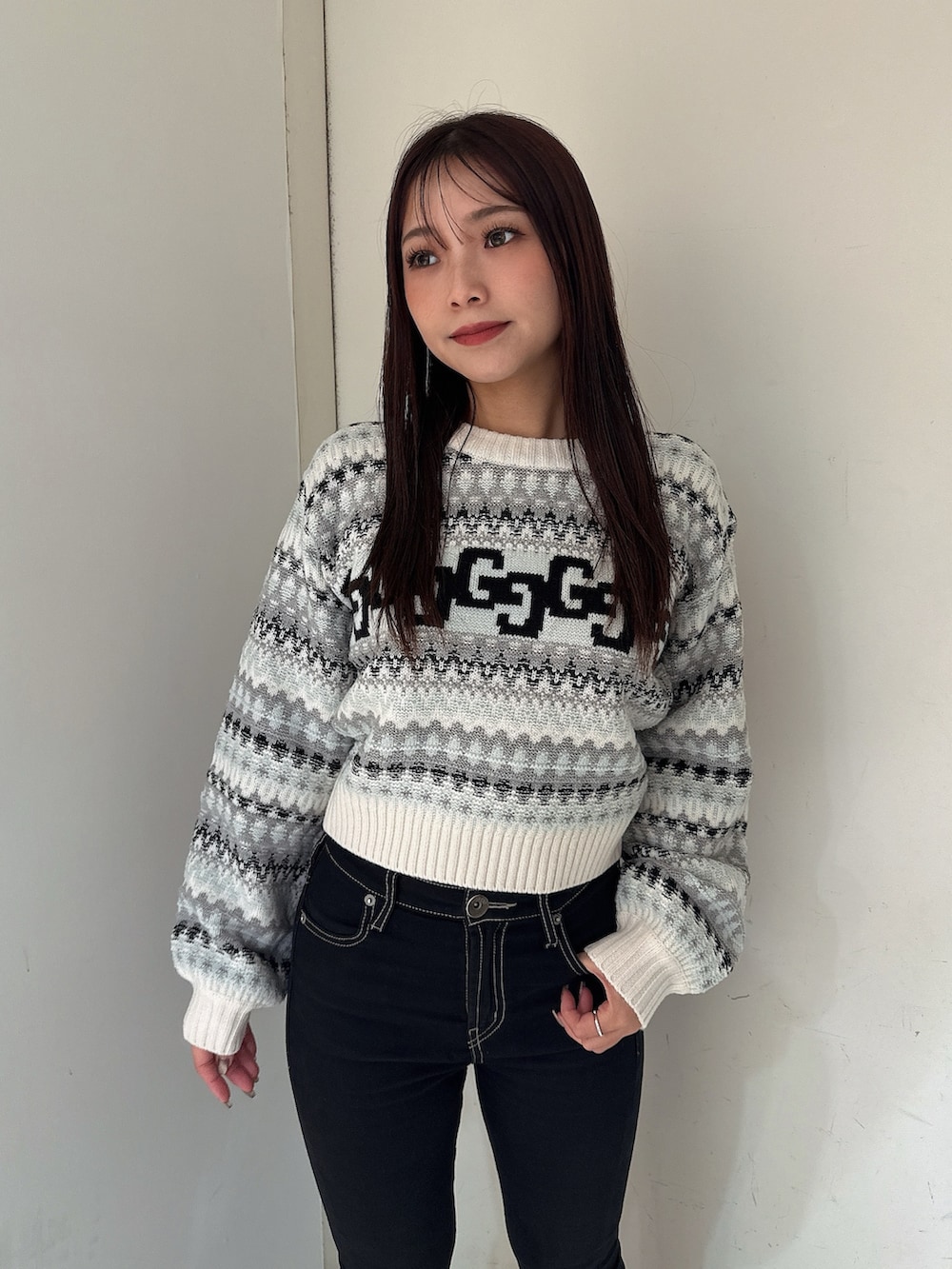 ブラック系のデニムパンツ、ブラック系のブーツ、ホワイト系のニット/セーターを着用したレディースの秋コーディネートの4枚目の写真