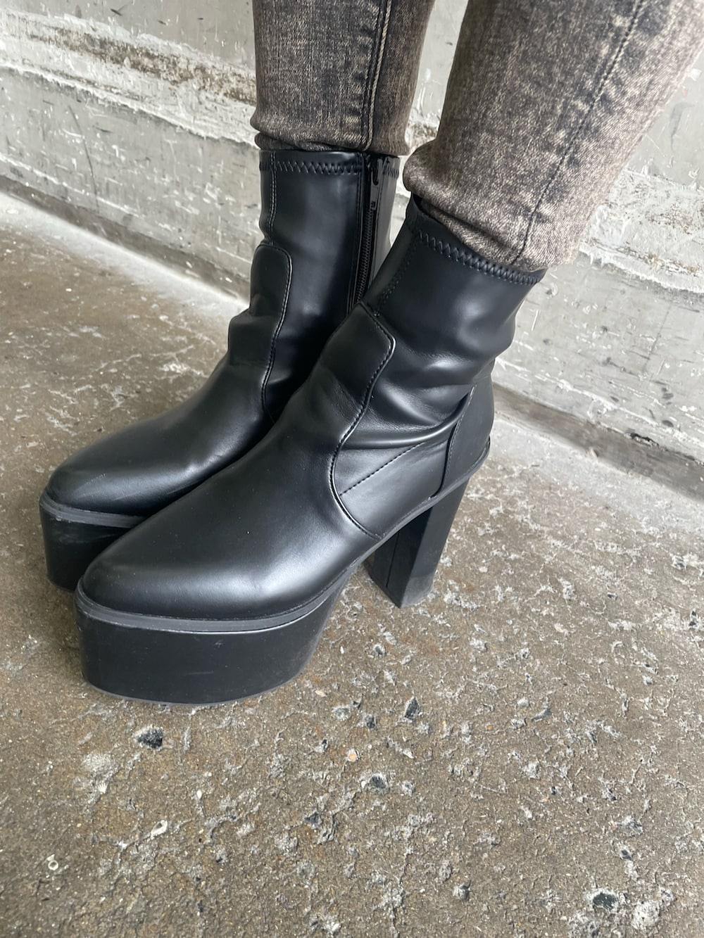 ブラック系のパーカー、ブラック系のデニムパンツ、ブラック系のブーツを着用したレディースの秋コーディネートの10枚目の写真