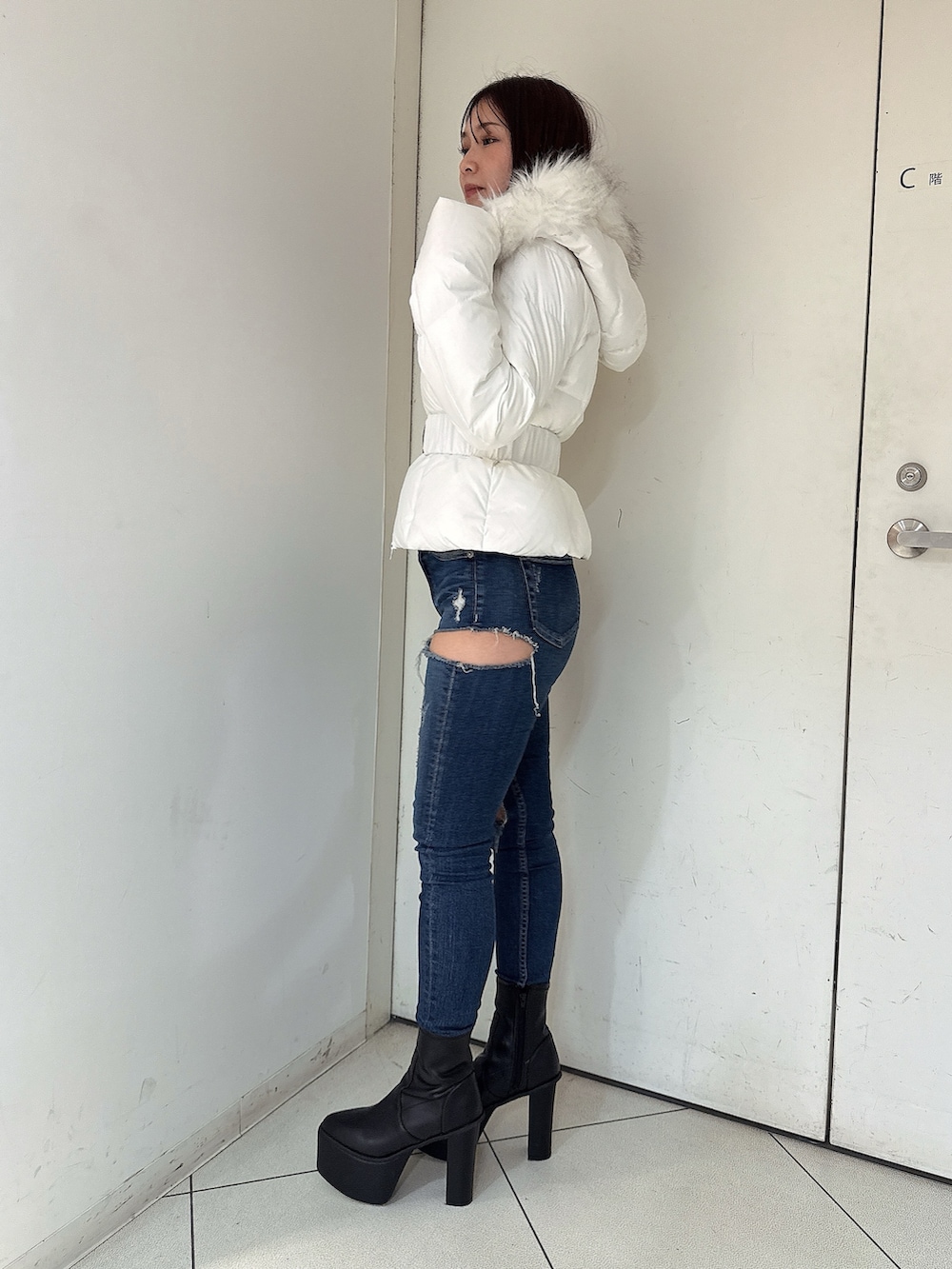 ホワイト系のダウンジャケット/コート、ブルー系のデニムパンツ、ブラック系のブーツを着用したレディースの秋コーディネートの2枚目の写真