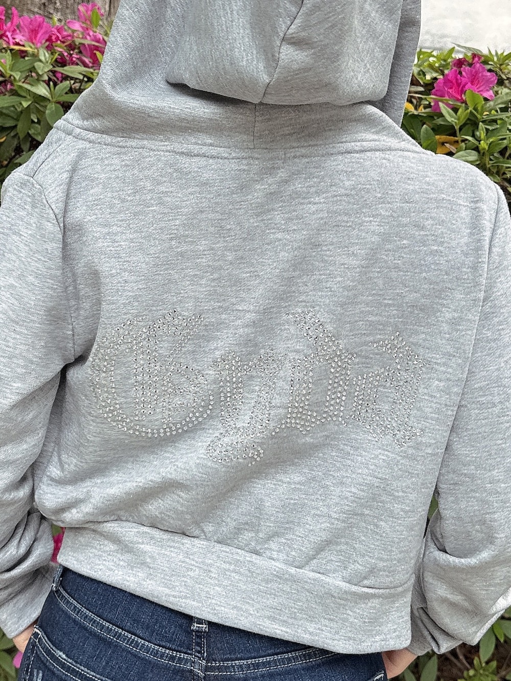 グレー系のパーカー、ブルー系のデニムパンツ、ホワイト系のサンダルを着用したレディースの春コーディネートの7枚目の写真