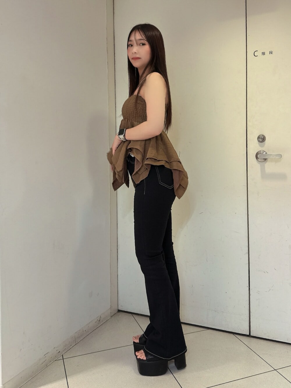 ブラック系のデニムパンツ、ブラック系のサンダル、ベージュ系のキャミソールを着用したレディースの夏コーディネートの2枚目の写真