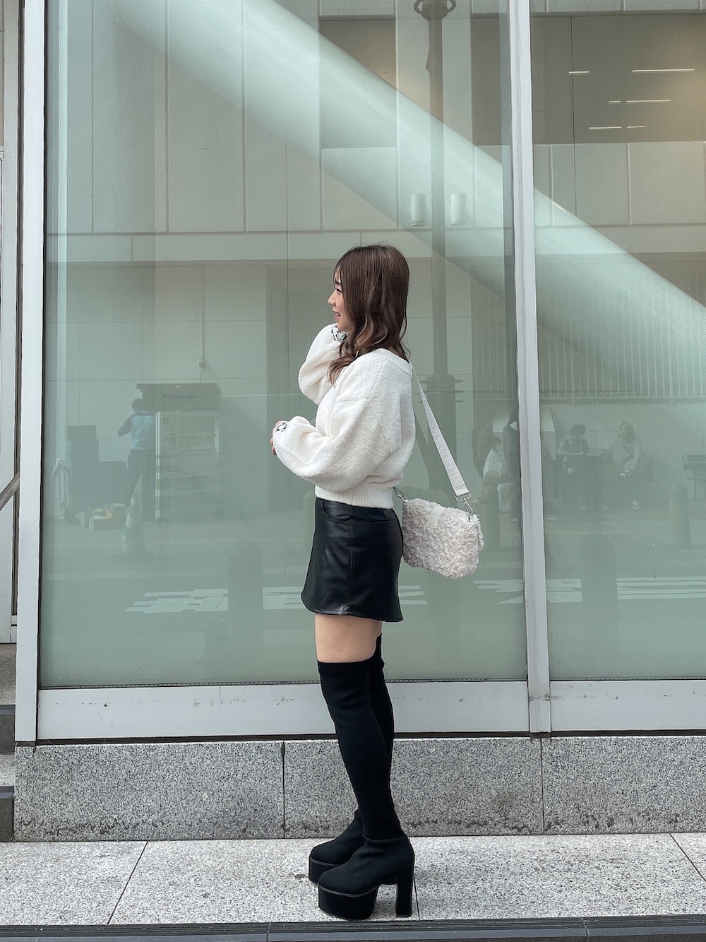 ホワイト系のニット/セーター、ホワイト系のハンドバッグ、ブラック系のスカートを着用したレディースの秋コーディネートの2枚目の写真