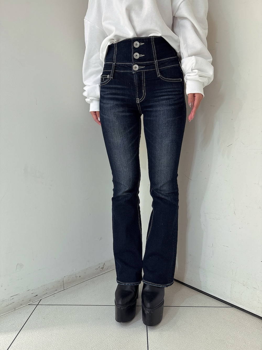 ブルー系のデニムパンツ、ブラック系のブーツ、ホワイト系のスウェットを着用したレディースの秋コーディネートの8枚目の写真