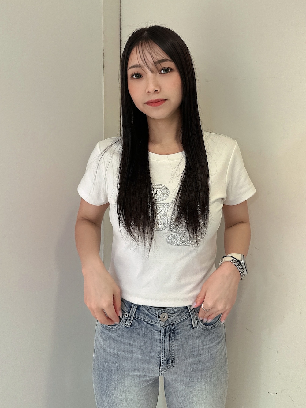 ブルー系のデニムパンツ、ホワイト系のTシャツ/カットソー、ホワイト系のサンダルを着用したレディースの春コーディネートの4枚目の写真