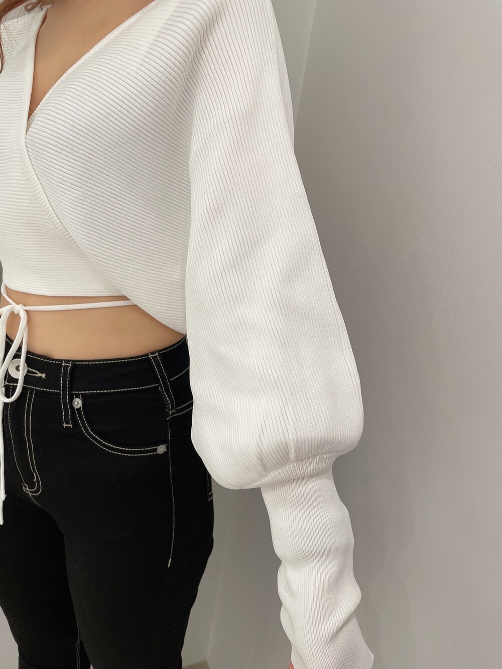 ブラック系のデニムパンツ、ブラック系のハンドバッグ、ホワイト系のパンプスを着用したレディースの春コーディネートの7枚目の写真