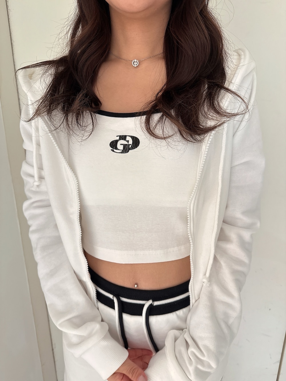 ホワイト系のキャミソール、ブラック系のサンダル、ホワイト系のパーカーを着用したレディースの夏コーディネートの7枚目の写真