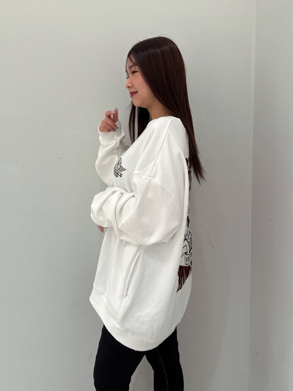 ブラック系のデニムパンツ、ホワイト系のスウェット、ブラック系のブーツを着用したレディースの夏コーディネートの5枚目の写真