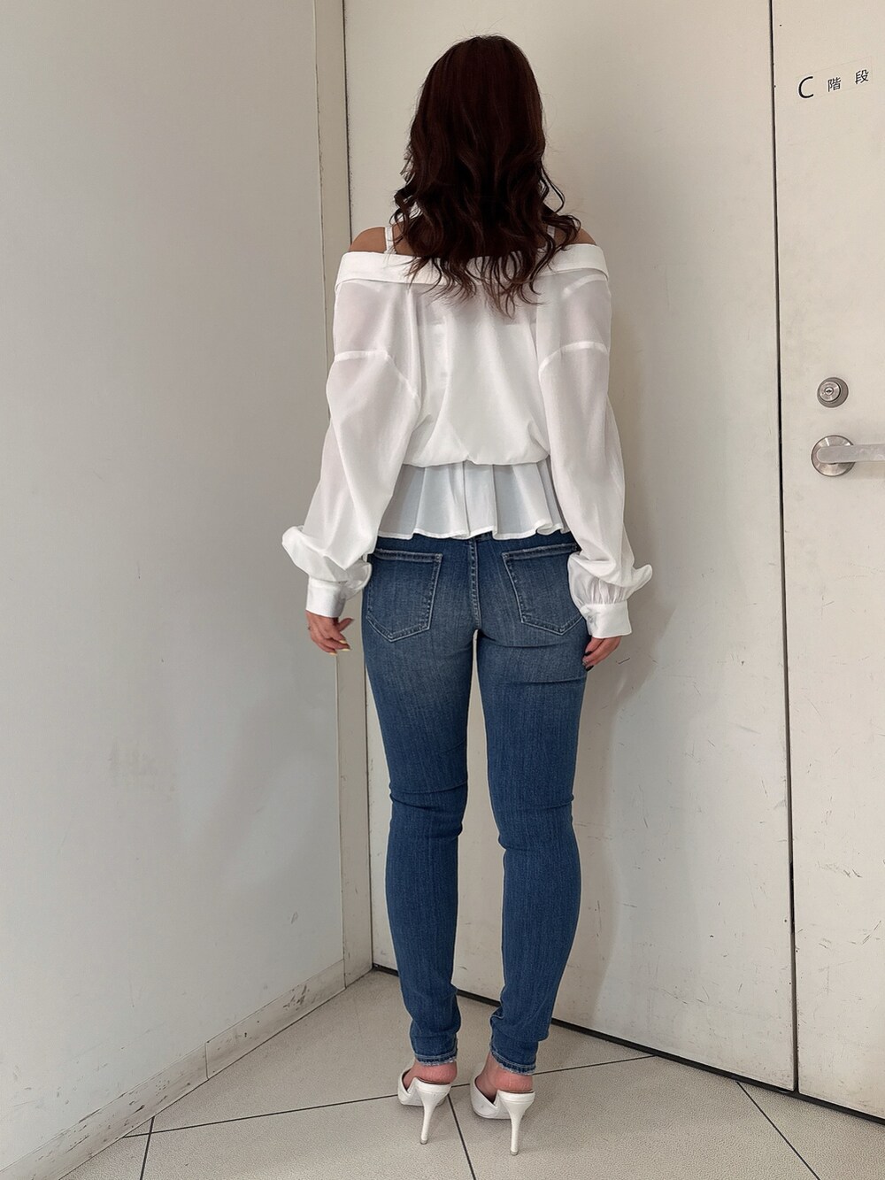 ブルー系のデニムパンツ、ホワイト系のパンプス、ホワイト系のシャツ/ブラウスを着用したレディースの冬コーディネートの3枚目の写真