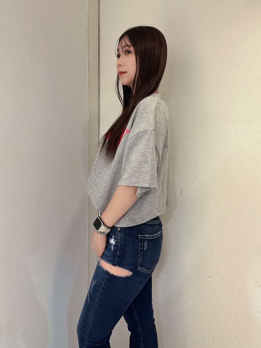 ブルー系のデニムパンツ、ブラック系のサンダル、グレー系のTシャツ/カットソーを着用したレディースの夏コーディネートの5枚目の写真