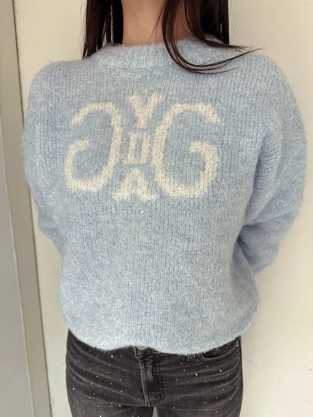 ブラック系のブーツ、ブルー系のニット/セーター、ブラック系のデニムパンツを着用したレディースの冬コーディネートの7枚目の写真