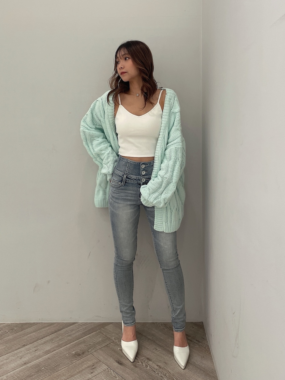 ホワイト系のキャミソール、ブルー系のデニムパンツ、グリーン系のカーディガン/ボレロを着用したレディースの冬コーディネートの2枚目の写真