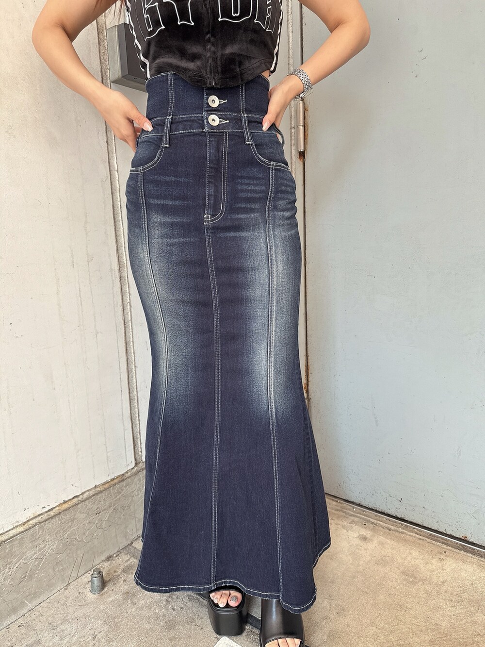 ブラック系のキャミソール、ブルー系のデニムスカート、ブラック系のサンダルを着用したレディースの夏コーディネートの7枚目の写真