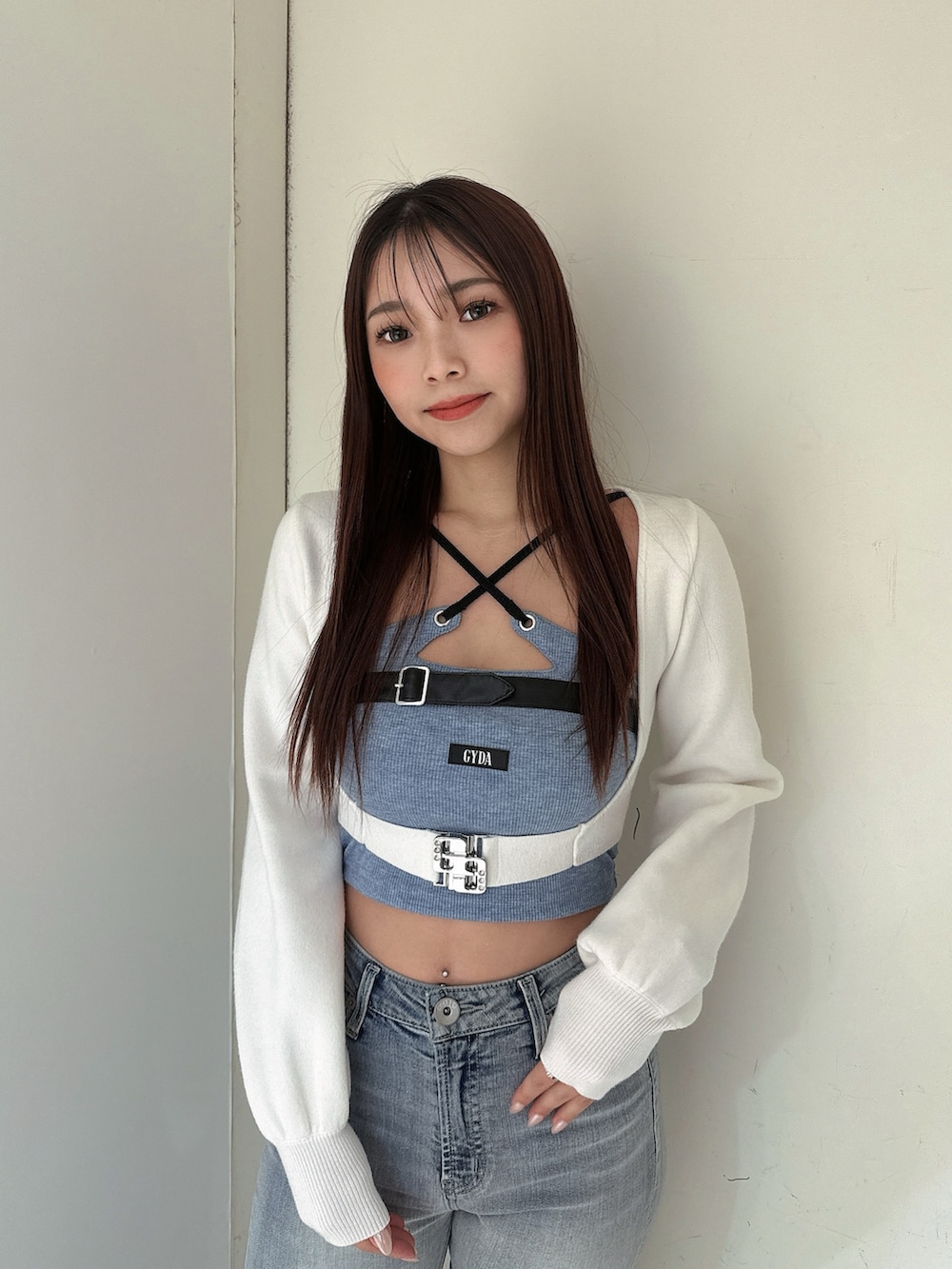 ブルー系のデニムパンツ、ブラック系のサンダル、ホワイト系のカーディガン/ボレロを着用したレディースの春コーディネートの4枚目の写真