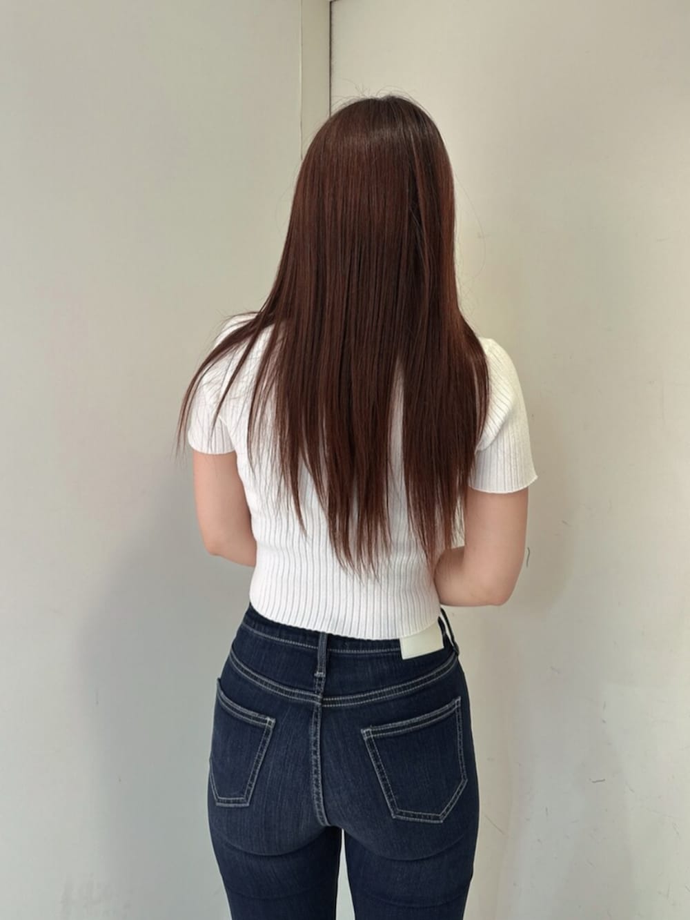 ブルー系のデニムパンツ、ブラック系のサンダル、ホワイト系のニット/セーターを着用したレディースの春コーディネートの6枚目の写真