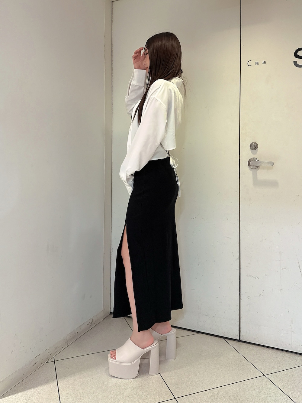 ブラック系のワンピース、ホワイト系のシャツ/ブラウス、ホワイト系のサンダルを着用したレディースの夏コーディネートの2枚目の写真