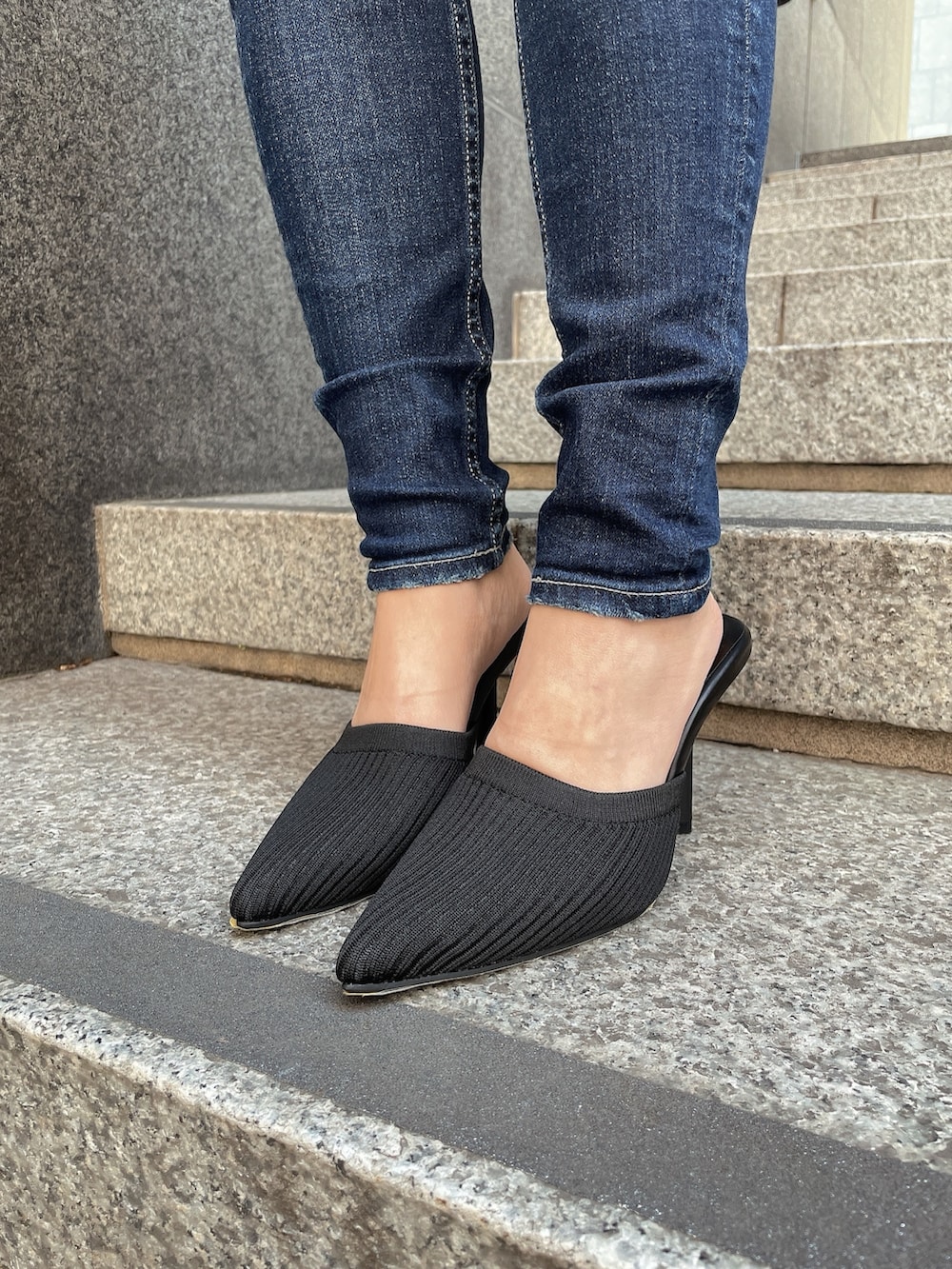ブラック系のニット/セーター、ブルー系のデニムパンツ、ブラック系のパンプスを着用したレディースの冬コーディネートの9枚目の写真