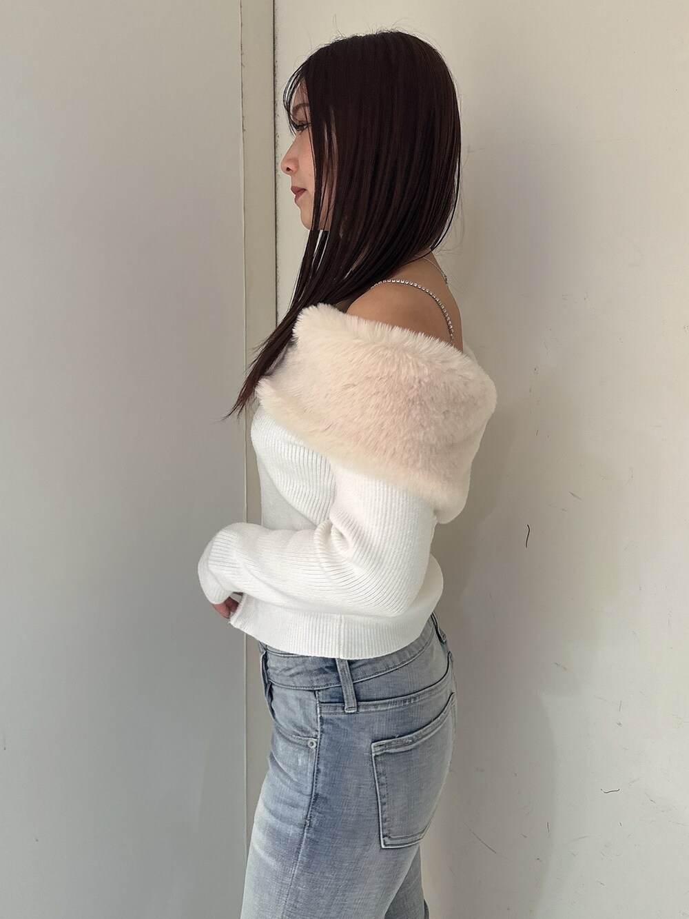 ホワイト系のニット/セーター、ブルー系のデニムパンツ、ブラック系のブーツを着用したレディースの秋コーディネートの5枚目の写真