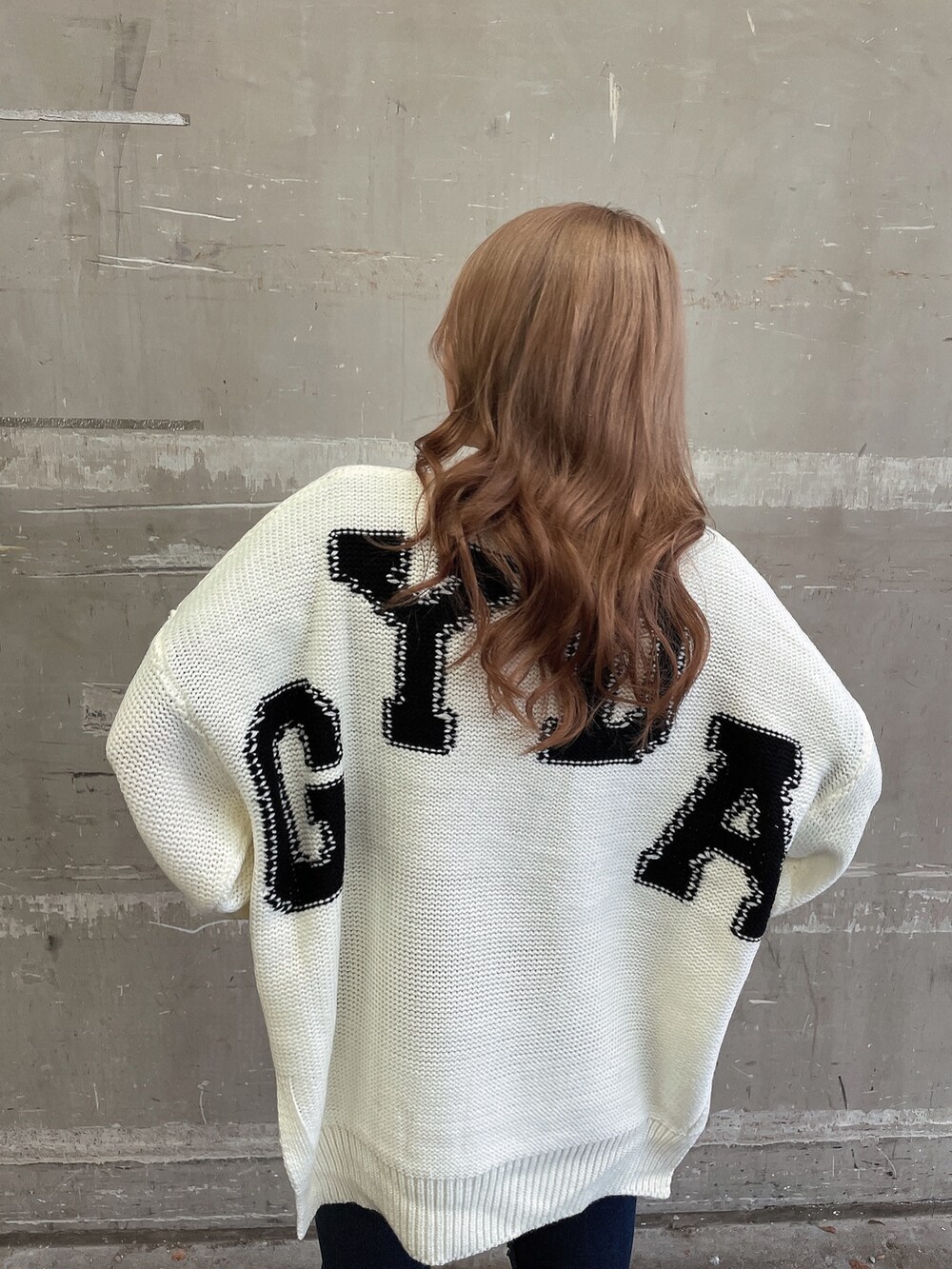 ホワイト系のニット/セーター、ブルー系のデニムパンツ、ブラック系のブーツを着用したレディースの冬コーディネートの6枚目の写真