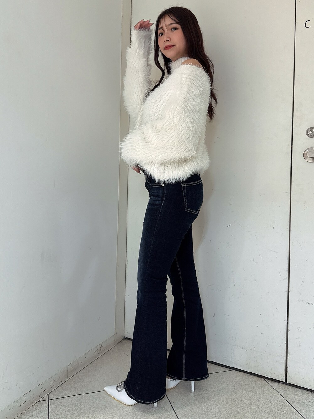 ホワイト系のニット/セーター、ブルー系のデニムパンツ、ホワイト系のパンプスを着用したレディースの秋コーディネートの2枚目の写真
