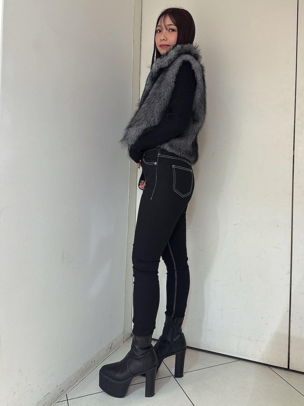 ブラック系のニット/セーター、ブラック系のデニムパンツ、ブラック系のブーツを着用したレディースの秋コーディネートの2枚目の写真