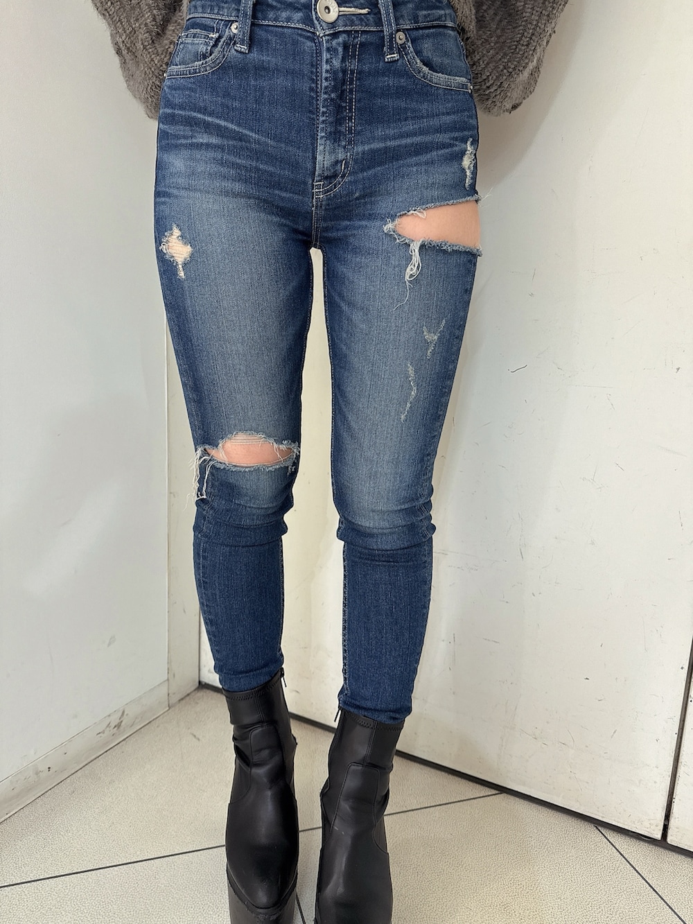 ブルー系のデニムパンツ、ブラック系のブーツ、グレー系のニット/セーターを着用したレディースの秋コーディネートの8枚目の写真