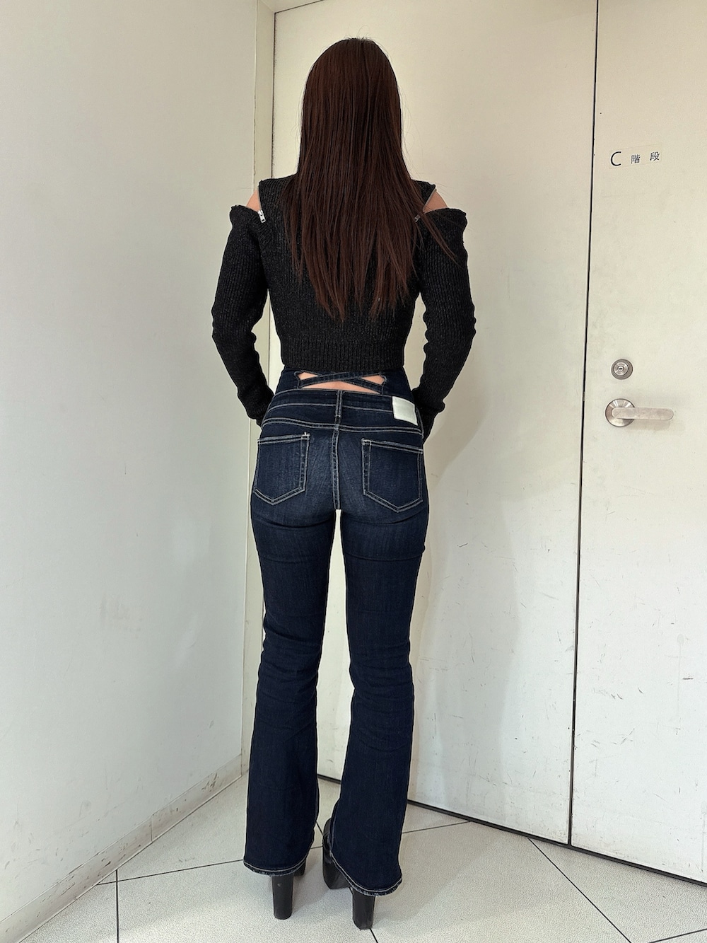 ブルー系のデニムパンツ、ブラック系のブーツ、ブラック系のニット/セーターを着用したレディースの冬コーディネートの3枚目の写真