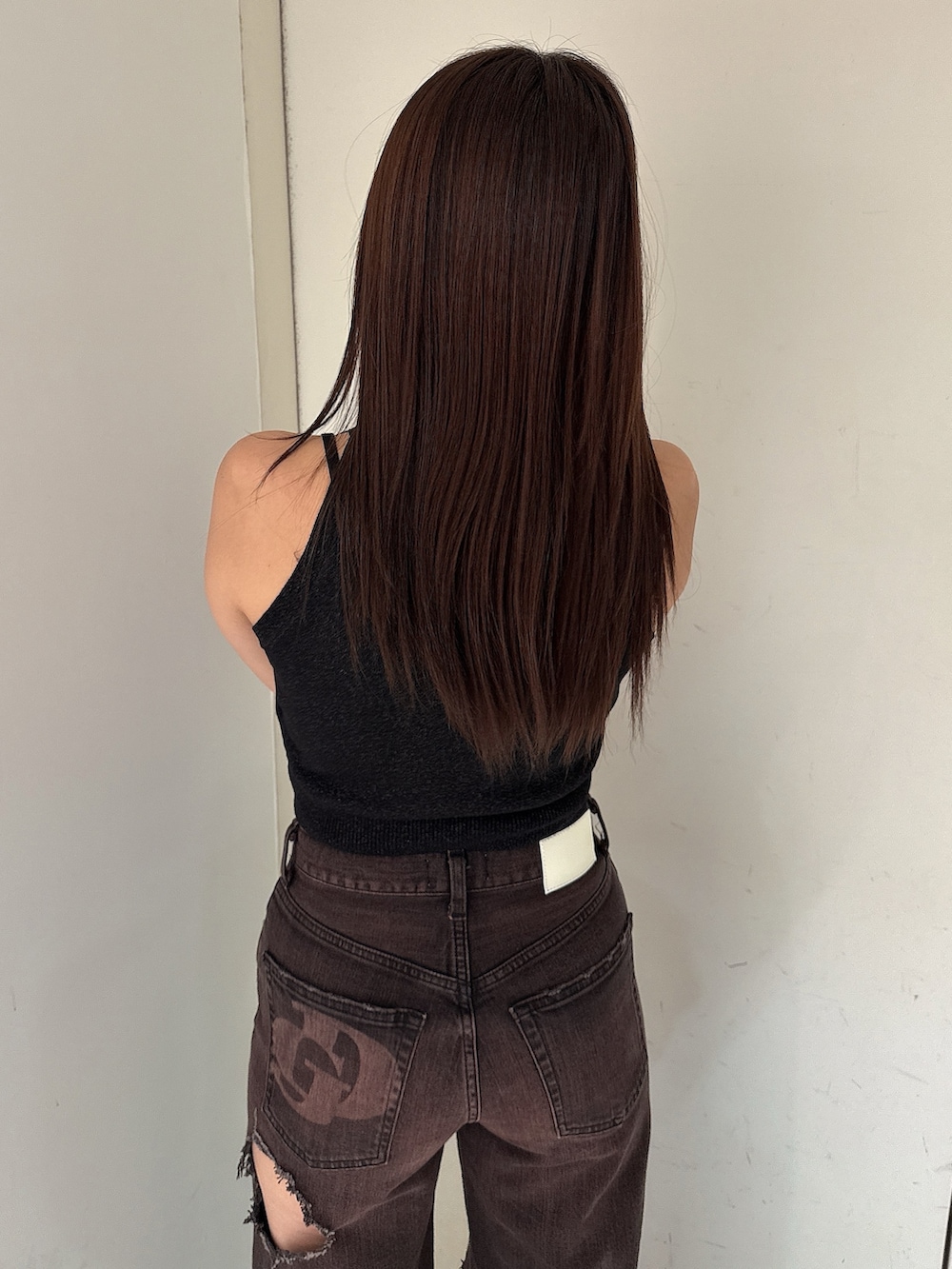 ピンク系のニット/セーター、ブラック系のサンダル、ブラック系のデニムパンツを着用したレディースの夏コーディネートの6枚目の写真