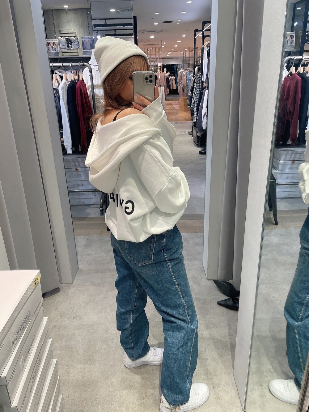 ブラック系のキャミソール、ホワイト系のパーカー、グリーン系のダウンジャケット/コートを着用したレディースの秋コーディネートの4枚目の写真