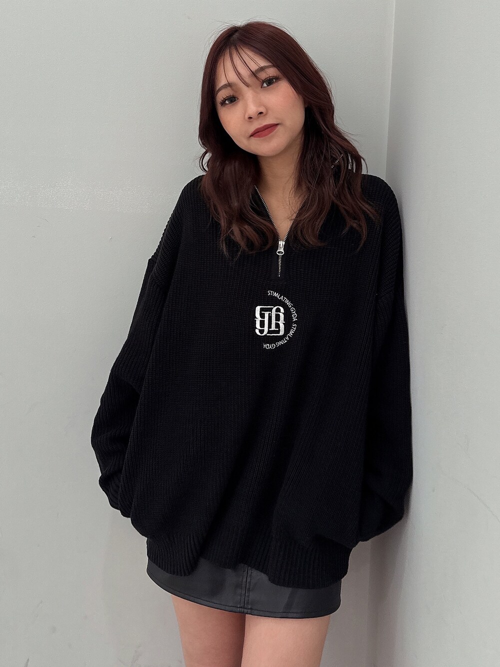 ブラック系のスカート、ブラック系のニット/セーター、ブラック系のブーツを着用したレディースの冬コーディネートの4枚目の写真