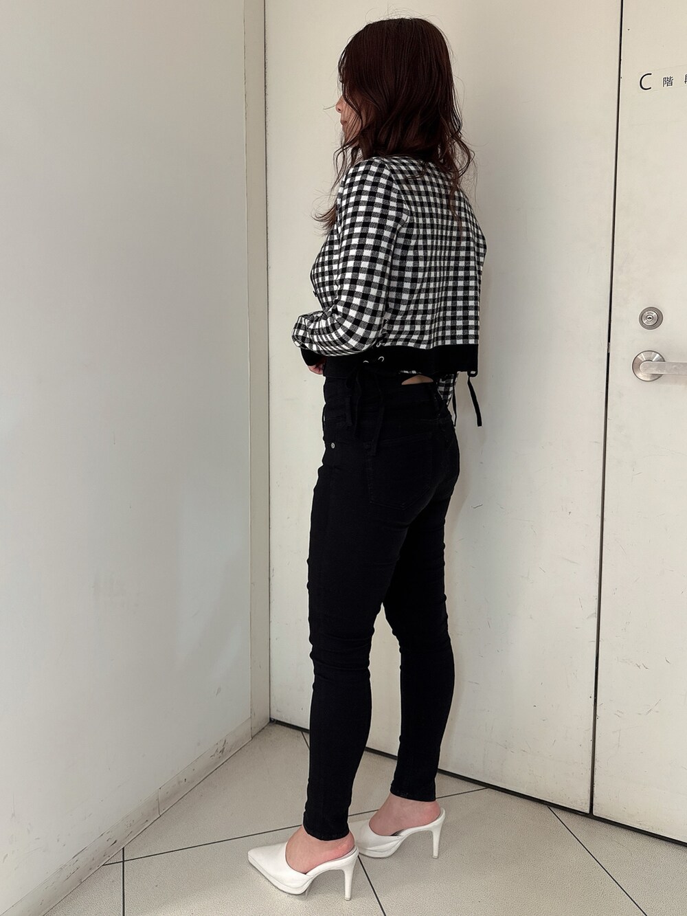 ブラック系のデニムパンツ、ホワイト系のパンプス、その他のニット/セーターを着用したレディースの春コーディネートの2枚目の写真