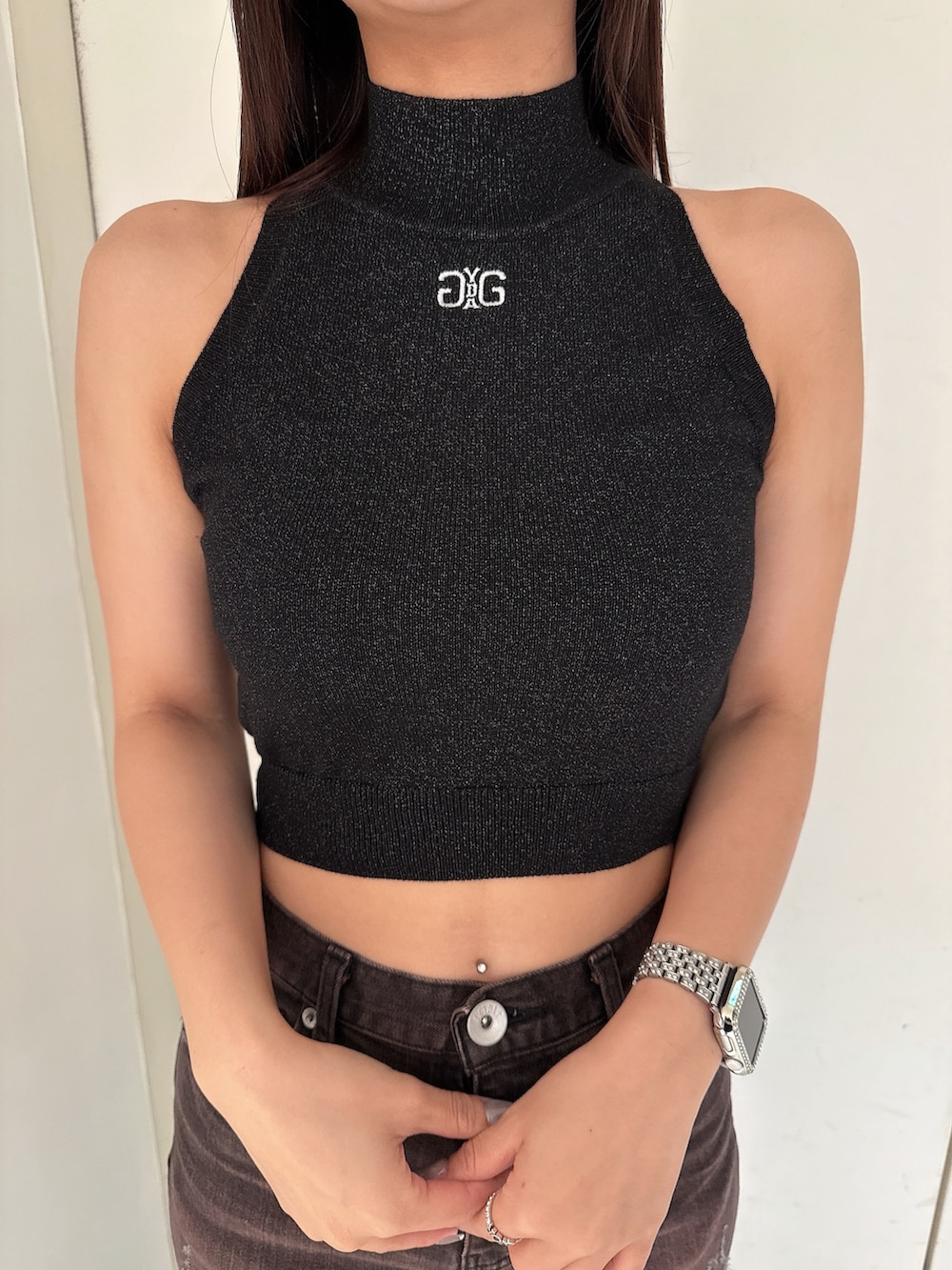 ピンク系のニット/セーター、ブラック系のサンダル、ブラック系のデニムパンツを着用したレディースの夏コーディネートの7枚目の写真