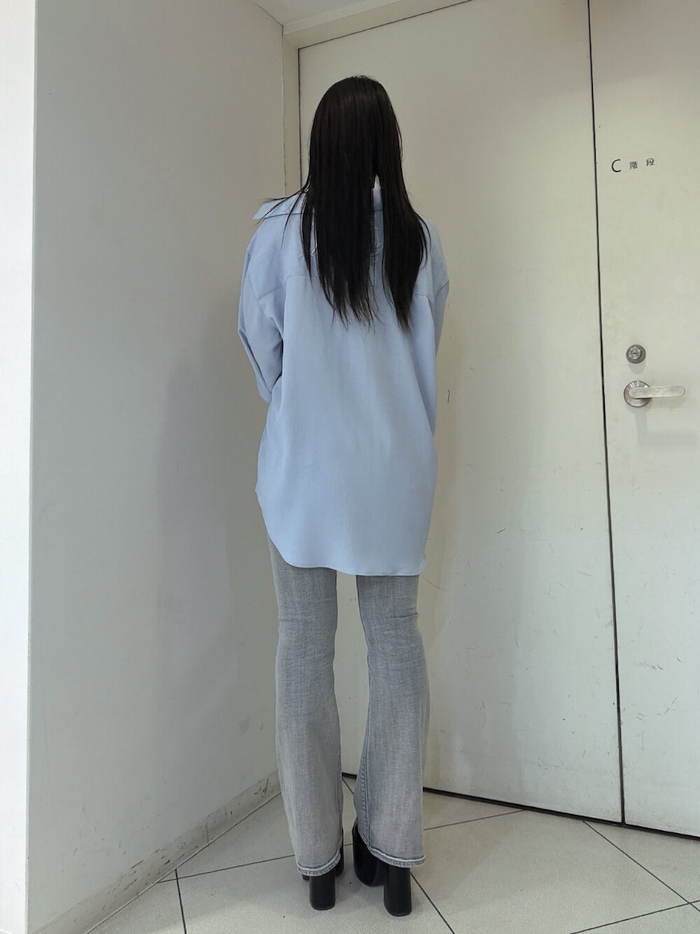 ブルー系のデニムパンツ、ブラック系のサンダル、ホワイト系のキャミソールを着用したレディースの春コーディネートの3枚目の写真