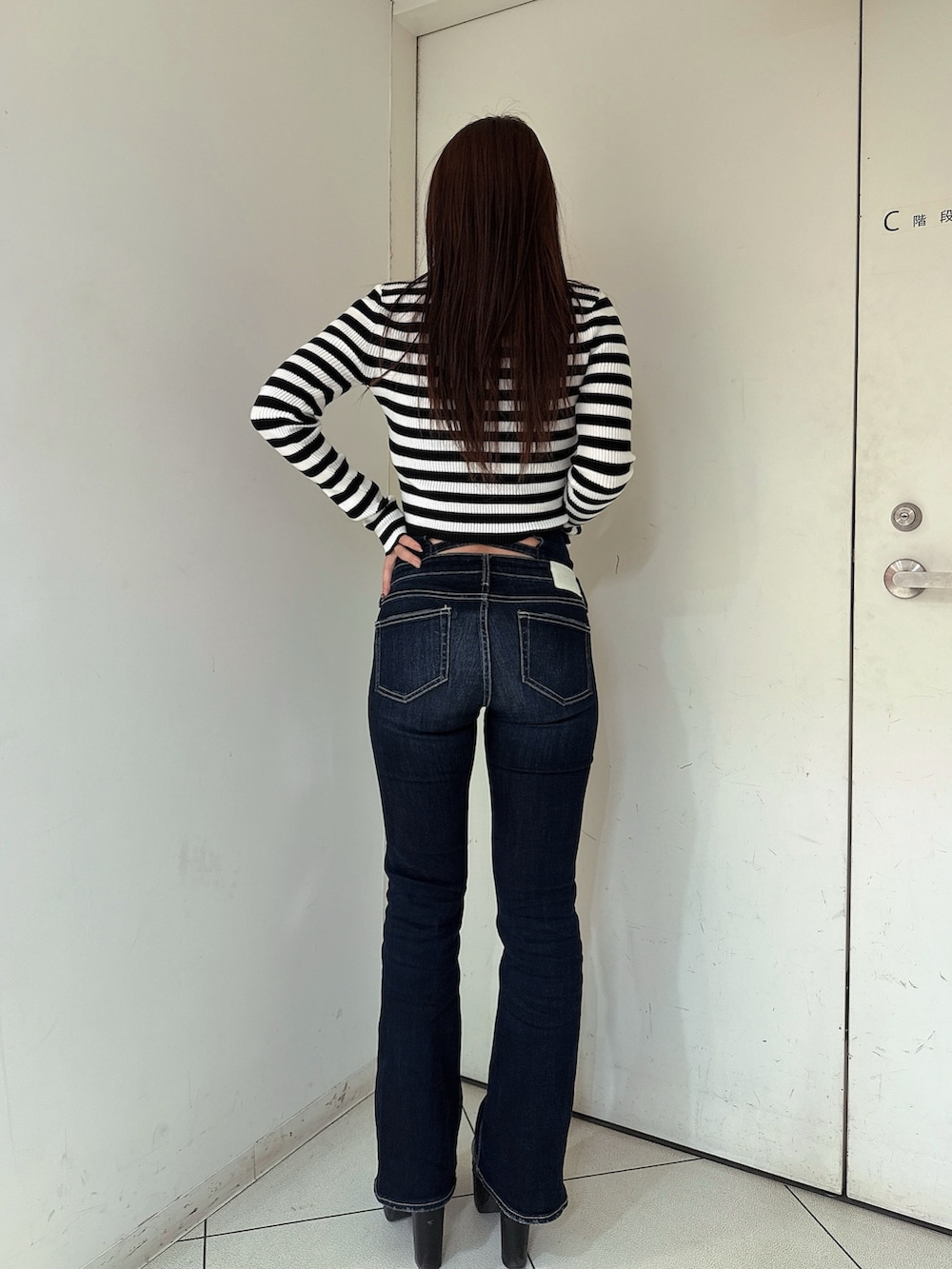 ブルー系のデニムパンツ、ブラック系のブーツ、その他のニット/セーターを着用したレディースの冬コーディネートの3枚目の写真