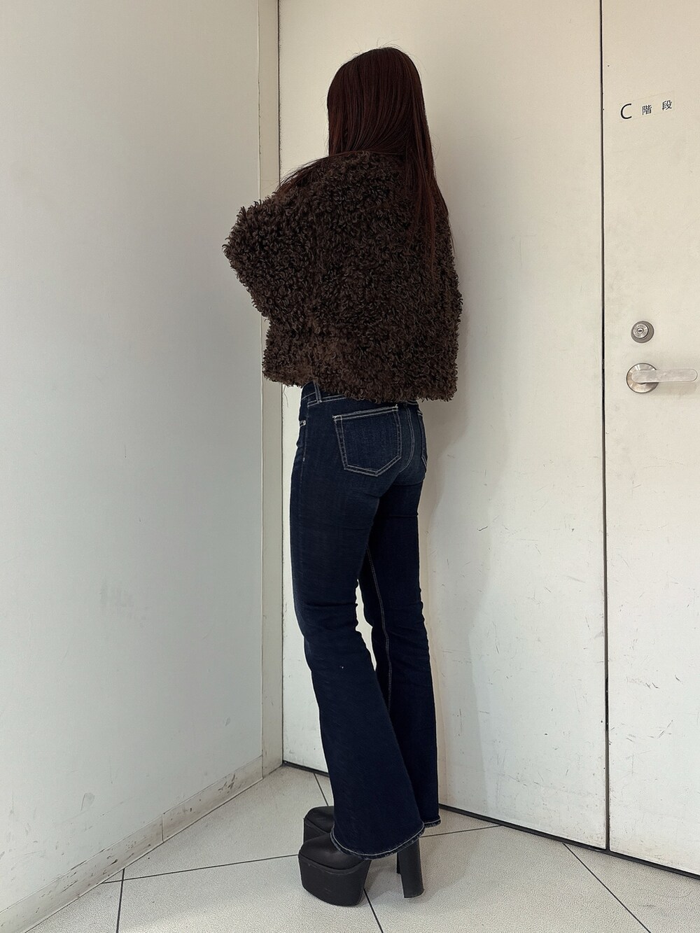 ブルー系のデニムパンツ、ブラック系のブーツ、ブラウン系のブルゾンを着用したレディースの秋コーディネートの2枚目の写真