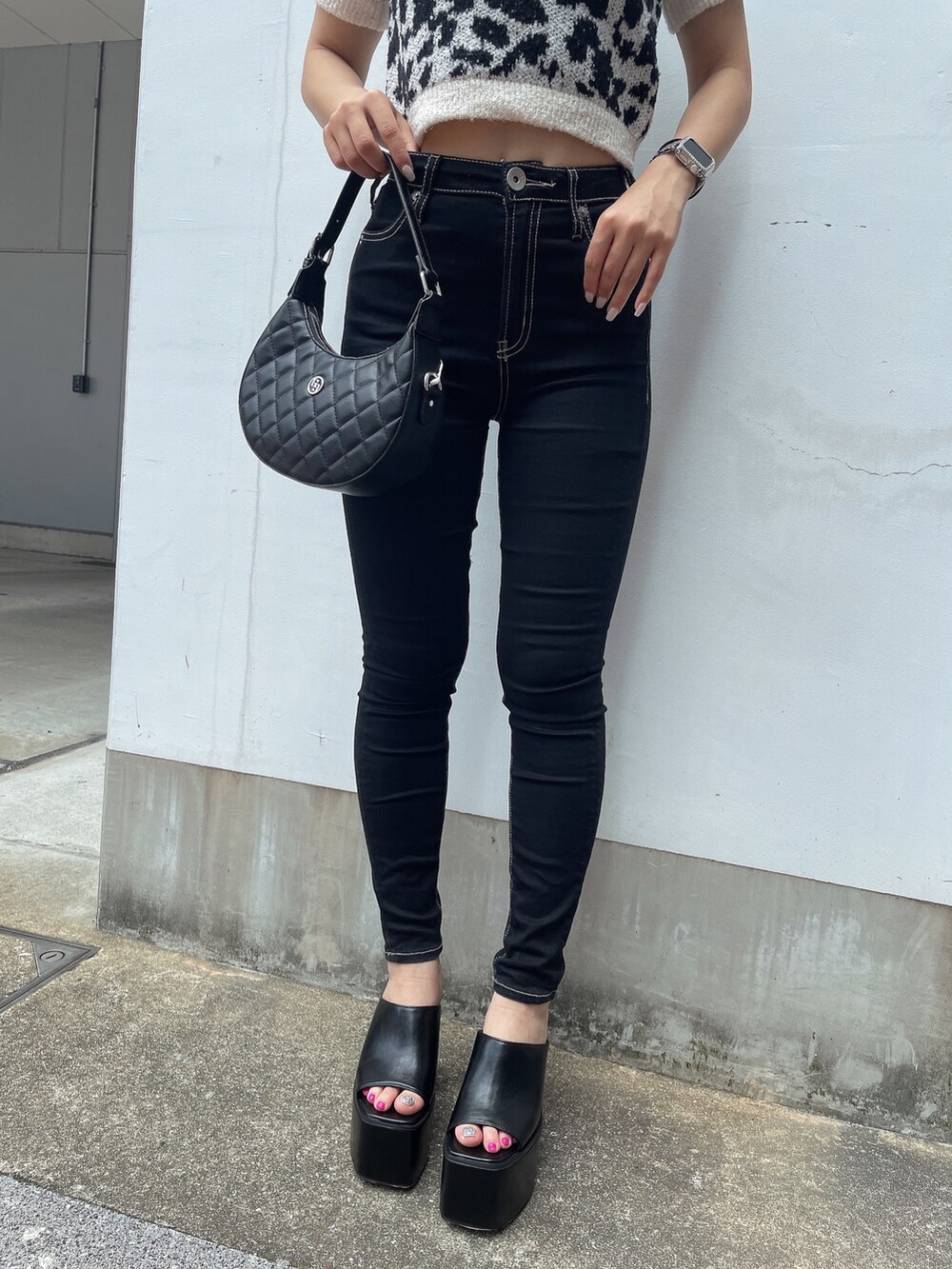 ホワイト系のニット/セーター、ブラック系のデニムパンツ、ブラック系のサンダルを着用したレディースの夏コーディネートの7枚目の写真