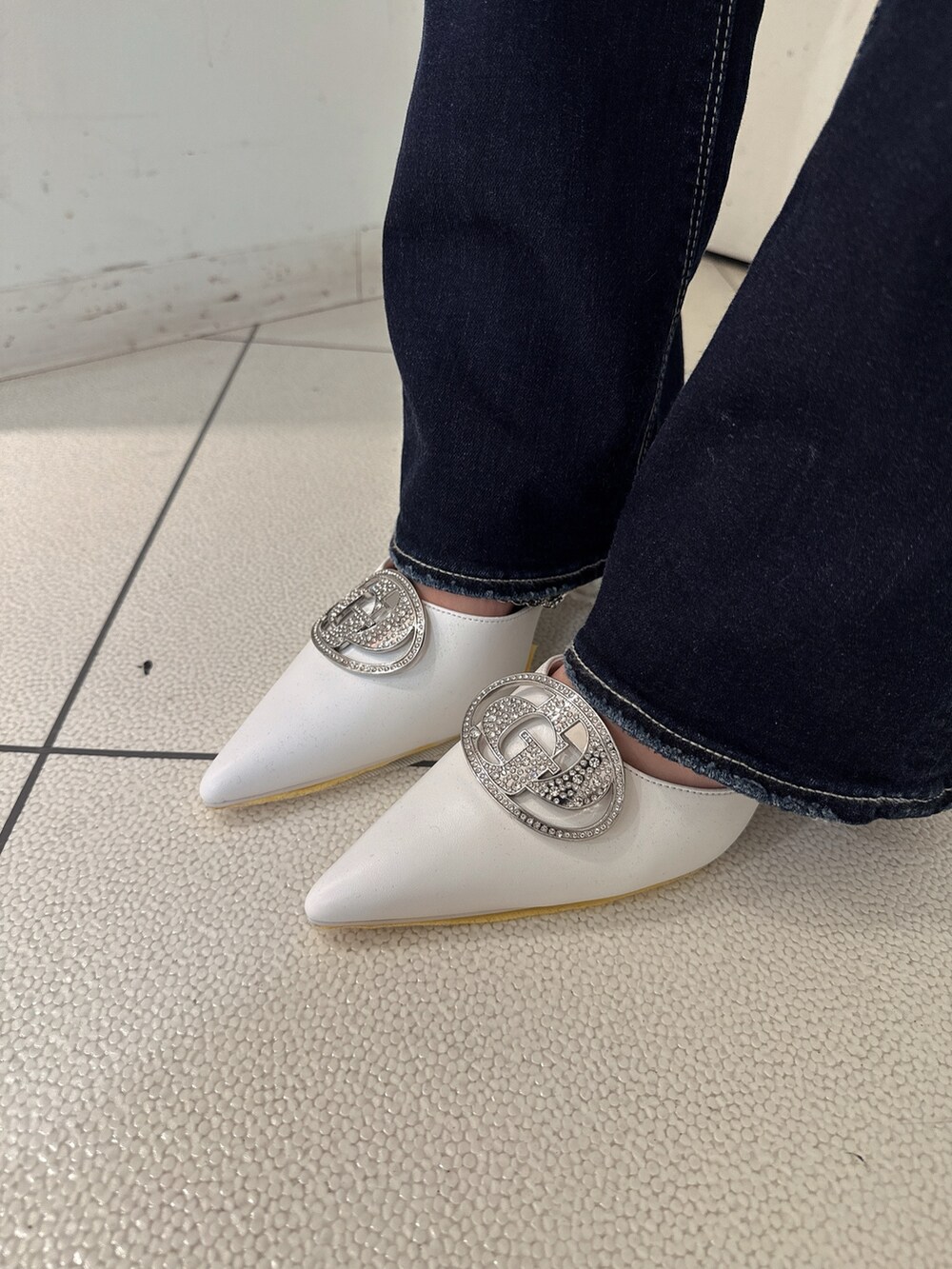 ホワイト系のニット/セーター、ブルー系のデニムパンツ、ホワイト系のパンプスを着用したレディースの秋コーディネートの9枚目の写真