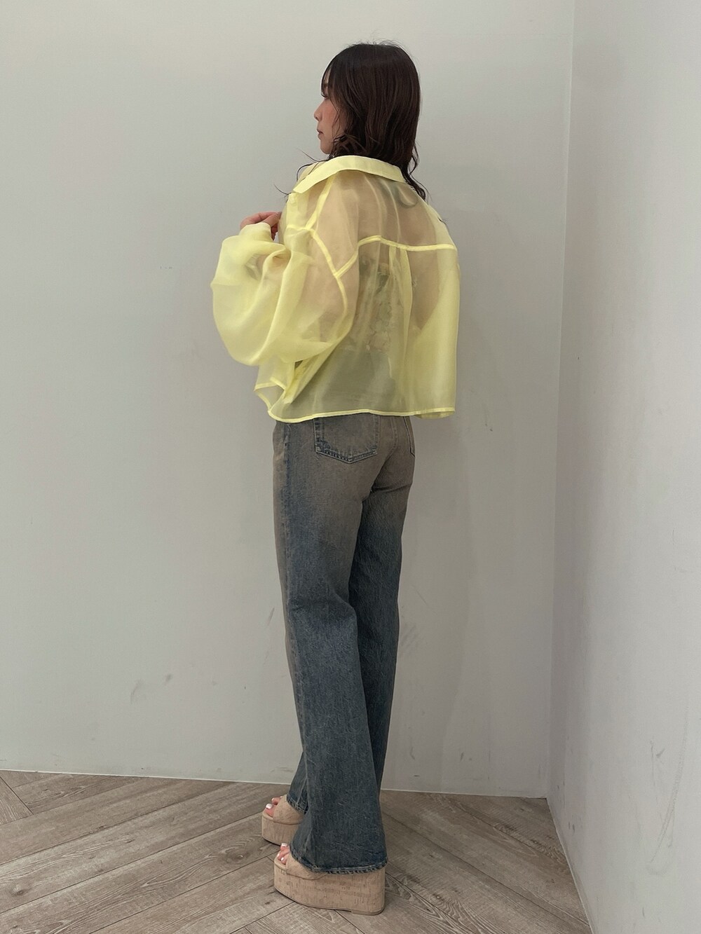 イエロー系のシャツ/ブラウス、ブラック系のチューブトップ、ブルー系のデニムパンツを着用したレディースの春コーディネートの3枚目の写真