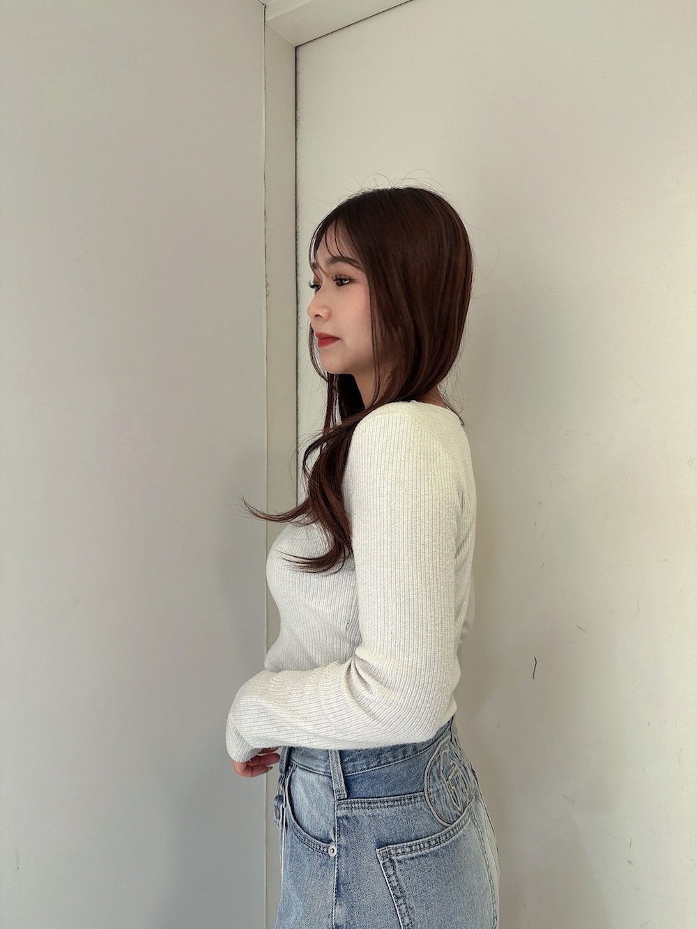 ブルー系のデニムパンツ、ブラック系のサンダル、ホワイト系のTシャツ/カットソーを着用したレディースの春コーディネートの5枚目の写真