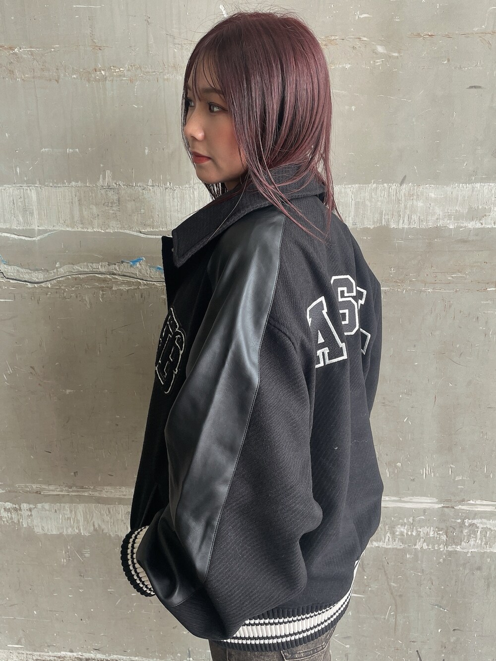 ブラック系のスタジャン、ブラック系のニット/セーター、ブラック系のデニムパンツを着用したレディースの秋コーディネートの5枚目の写真