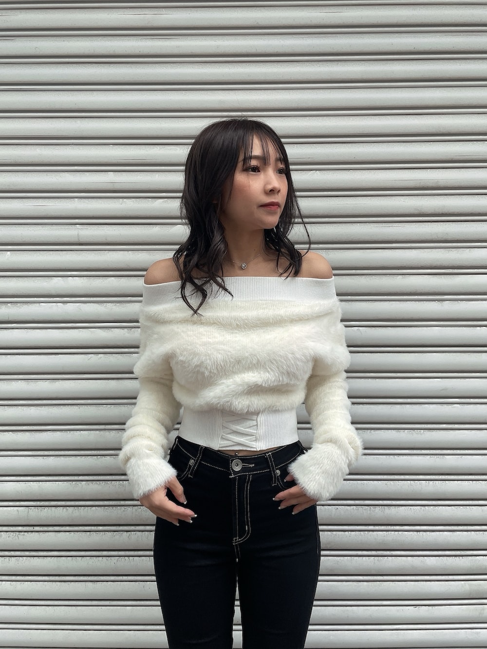 ブラック系のダウンジャケット/コート、ホワイト系のニット/セーター、ブラック系のデニムパンツを着用したレディースの冬コーディネートの7枚目の写真