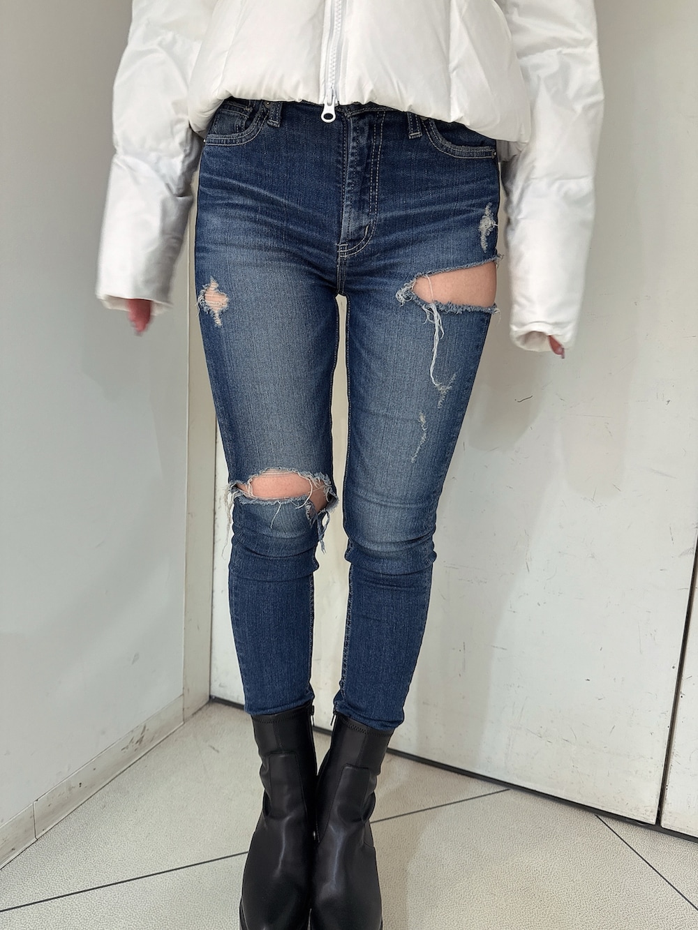 ホワイト系のダウンジャケット/コート、ブルー系のデニムパンツ、ブラック系のブーツを着用したレディースの秋コーディネートの8枚目の写真