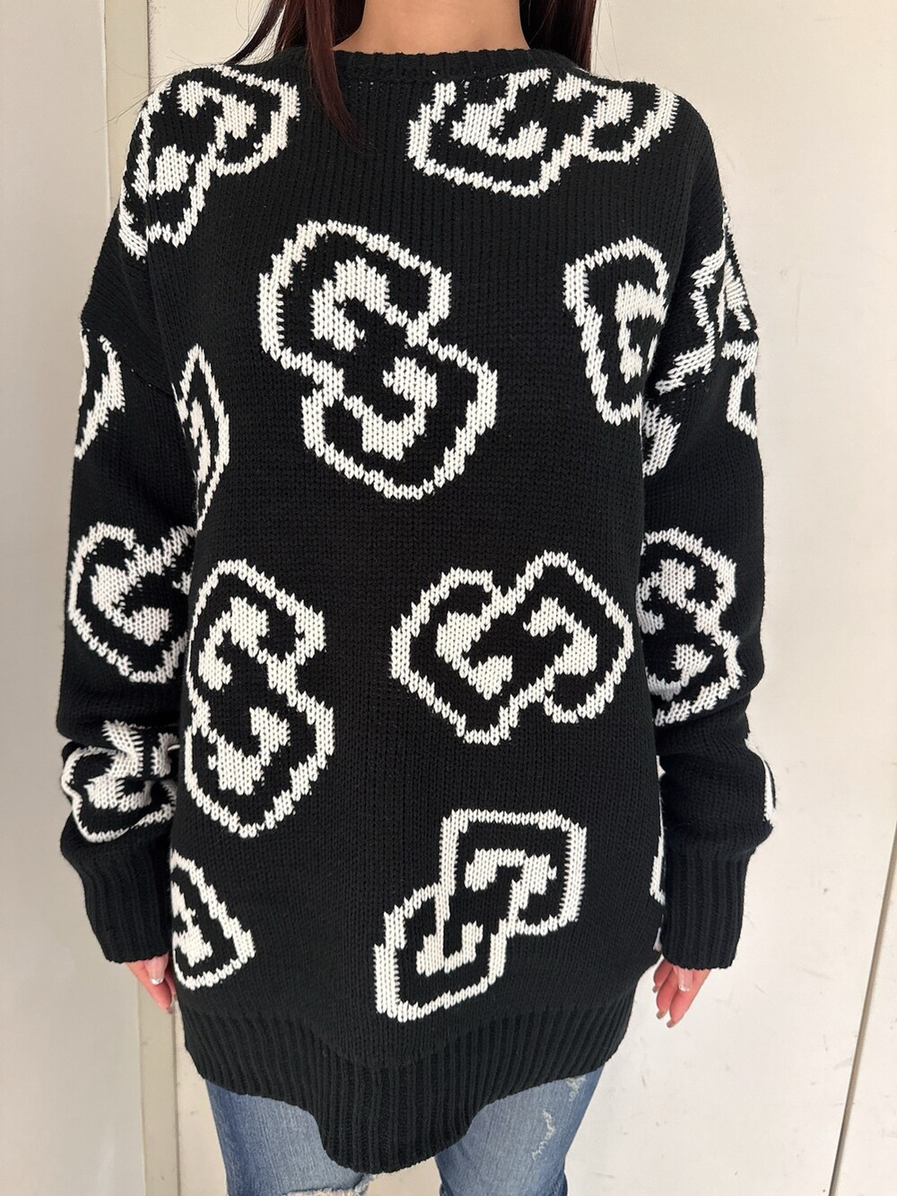 ブラック系のブーツ、ブルー系のデニムパンツ、ブラック系のニット/セーターを着用したレディースの秋コーディネートの7枚目の写真